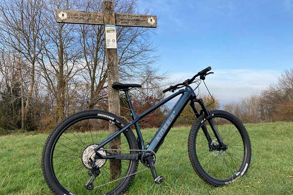 an e bike leaning against a south downs way marker post