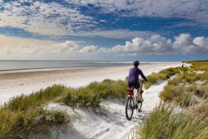 someone riding a bike along West Wittering Beach