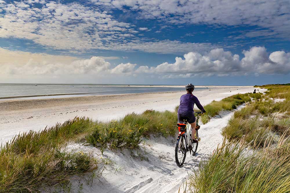 someone riding a bike along West Wittering Beach