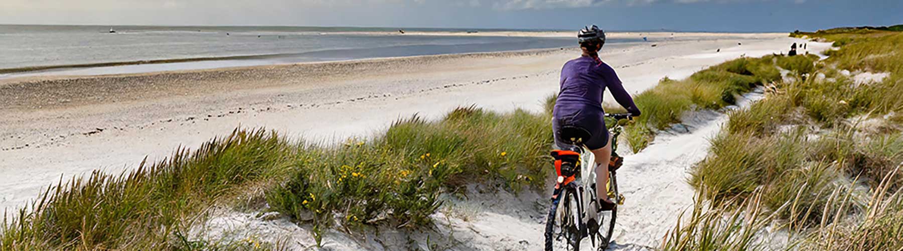 a cyclist rifding on the beach at West Witterings in West Sussex