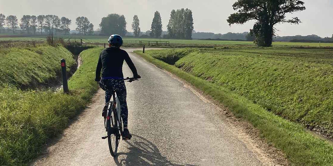 a woman riding on the Salterns Way on a e touring bike